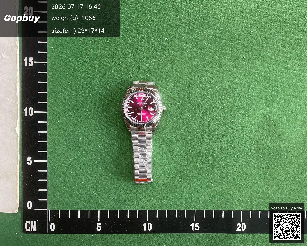 Silver bracelet watch with a pink dial on a measuring mat